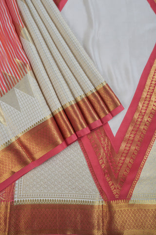 Ivory saree with gold zari checks, coral pink stripes and a triangular zari pattern leading into the pallu
