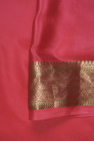 Ivory saree with gold zari checks, coral pink stripes and a triangular zari pattern leading into the pallu