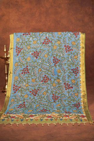 Sky blue Kalamkari saree with hand-painted floral vines, delicate gold zari border and hand-tied tassels