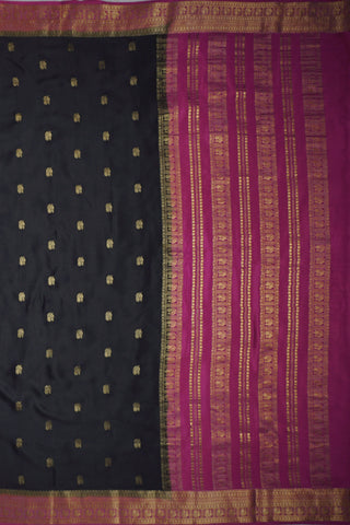 Black crepe silk saree with scattered gold peacock buttis, magenta pink border and zari striped pallu