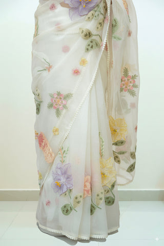 Pearl white tissue organza saree with 3D floral embroidery and lace scallop border.