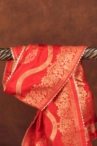 Red art silk dupatta with wavy gold zari leheriya lines, pink and orange meenakari vines and gold kiran lace edging