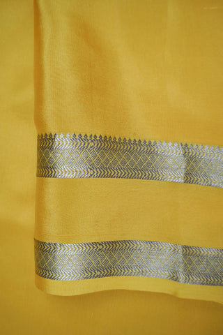 Draped off-white silk saree with a plain body, mustard yellow twin zari stripe border and yellow striped pallu