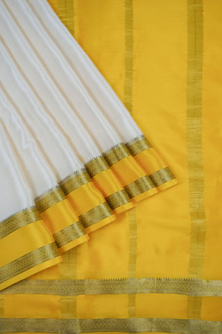 Draped off-white silk saree with a plain body, mustard yellow twin zari stripe border and yellow striped pallu