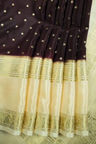Coffee brown crepe silk saree with small gold floral buttas, paisley zari border and contrasting beige blouse