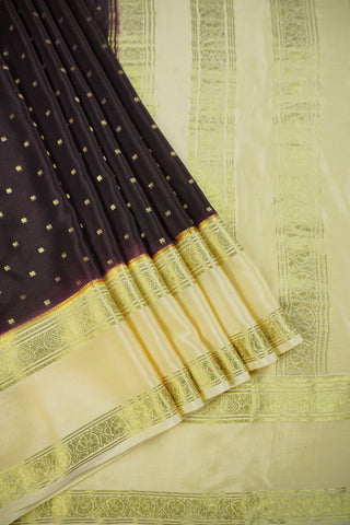 Coffee brown crepe silk saree with small gold floral buttas, paisley zari border and contrasting beige blouse