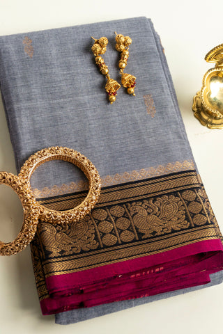 Grey Chettinad cotton saree with gold zari buttas and peacock border
