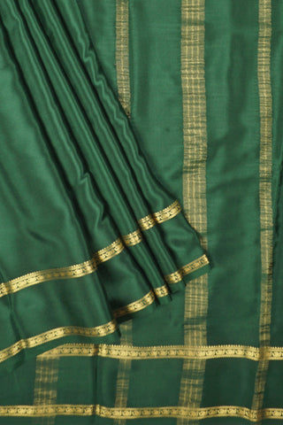 Bottle green crepe silk saree with paisley zari border