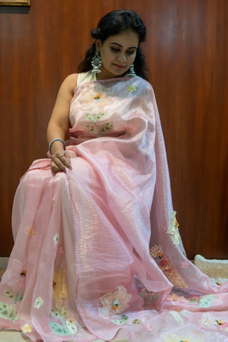 Blush pink tissue organza saree with 3D floral embroidery and lace border.