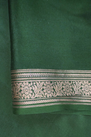 Mustard yellow silk saree with a bottle green border woven in gold zari floral and leaf motifs, striped pallu