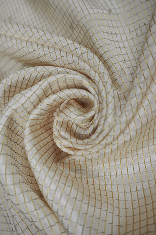 Off-white crepe silk saree with gold zari checks, mustard yellow paisley border and striped mustard pallu