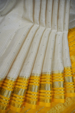Off-white crepe silk saree with gold zari checks, mustard yellow paisley border and striped mustard pallu