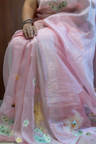 Blush pink tissue organza saree with 3D floral embroidery and lace border.