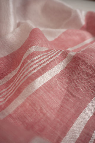 Coral pink linen saree with silver stripes and red border