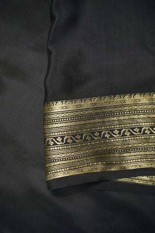 Ivory silk saree with gold pinstripes, a black zari lattice border with temple edges and a black striped pallu