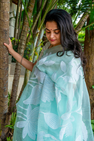 Mint green pure silk organza saree with floral and bird applique work.