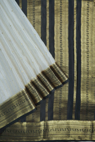 Ivory silk saree with gold pinstripes, a black zari lattice border with temple edges and a black striped pallu