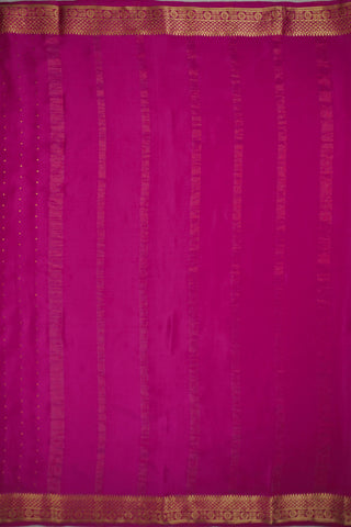Magenta pink crepe silk saree with scattered gold zari dots and a floral rosette border with lattice bands