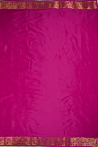 Magenta pink crepe silk saree with scattered gold zari dots and a floral rosette border with lattice bands
