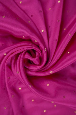 Magenta pink crepe silk saree with scattered gold zari dots and a floral rosette border with lattice bands
