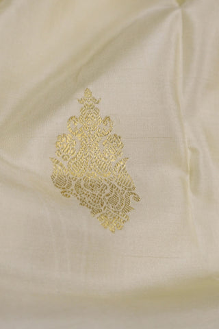 Off white Kanjivaram silk saree with gold zari paisley motifs and a deep maroon full brocade pallu