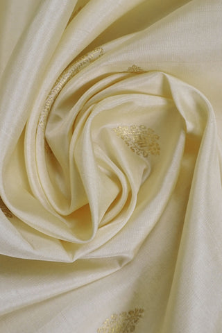 Off white Kanjivaram silk saree with gold zari paisley motifs and a deep maroon full brocade pallu