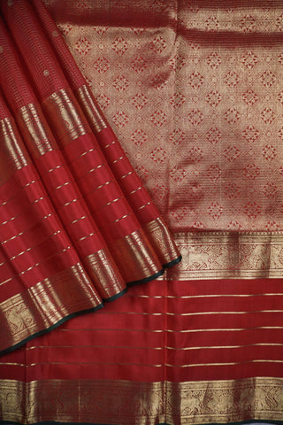 Ruby red Kanjivaram silk saree with gold micro checks, floral buttas and a bottle green selvedge border