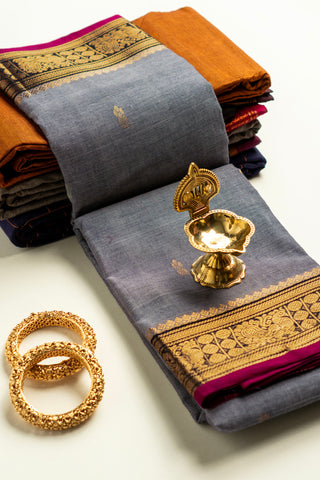 Grey Chettinad cotton saree with gold zari buttas and peacock border