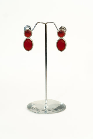 Silver replica drop earrings with two oval red stones set in a textured silver-tone frame