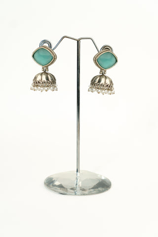Silver replica jhumka earrings with an aqua green cushion-cut stone in an oxidised frame and a pearl-trimmed dome