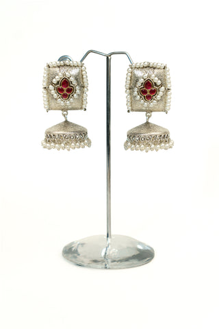 Square textured oxidised silver replica jhumkas with red stones, a pearl border and matching pearl drops