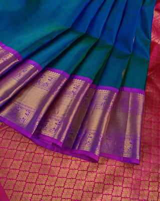 Teal green and blue dual-tone Kanjivaram saree with purple peacock border