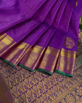 Purple Kanjivaram silk saree with gold zari stripes and green brocade pallu