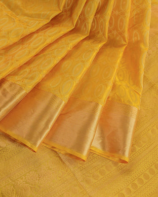 Golden yellow soft silk saree with gold zari oval motifs and peacock pallu design