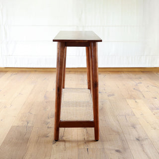 Teakwood console table with woven cane lower shelf and tapered legs