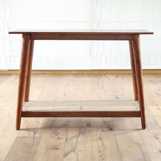 Teakwood console table with woven cane lower shelf and tapered legs