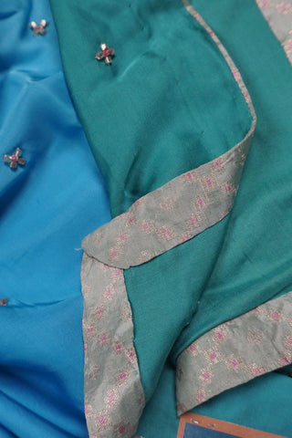 Light green to teal ombre modal silk saree with hand embroidered floral buttis and woven blouse